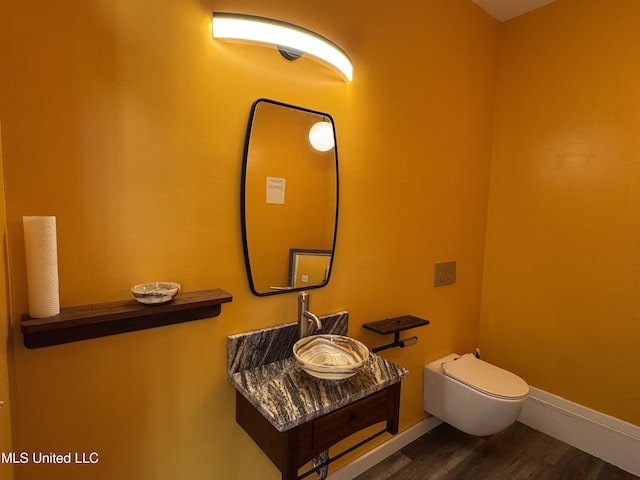 bathroom featuring hardwood / wood-style flooring, toilet, and sink