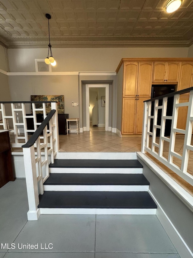 stairway featuring tile patterned floors and ornamental molding