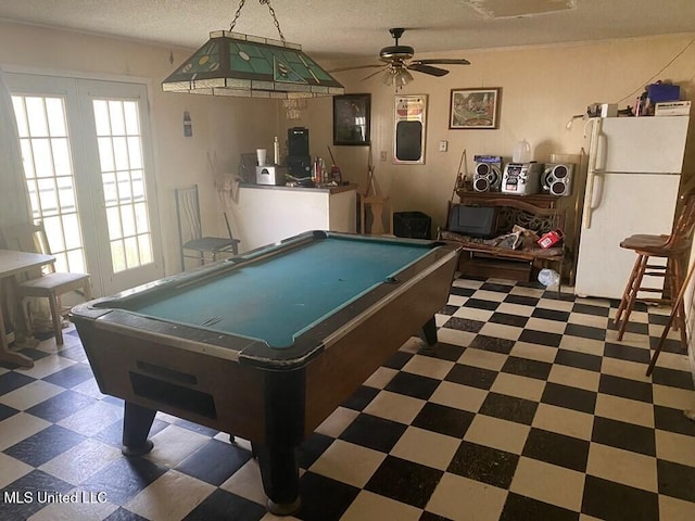 rec room with a textured ceiling, plenty of natural light, billiards, and tile patterned floors