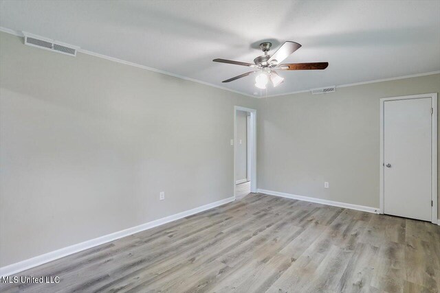 spare room with crown molding, light hardwood / wood-style floors, and ceiling fan