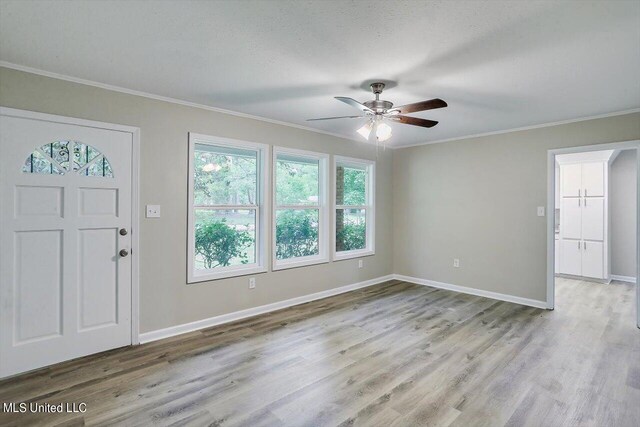 entrance foyer featuring ceiling fan, ornamental molding, and light hardwood / wood-style flooring