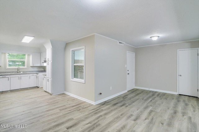 interior space with sink, a textured ceiling, white cabinetry, crown molding, and light hardwood / wood-style flooring