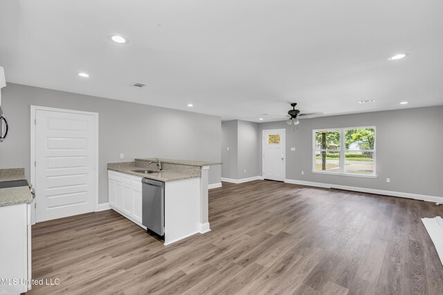 133 Maria St, Poplarville, MS 39470 - kitchen with stainless steel dishwasher, a sink, a ceiling fan, a peninsula, and white cabinets