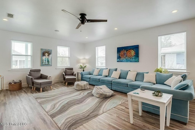 living area featuring baseboards, wood finished floors, visible vents, and recessed lighting