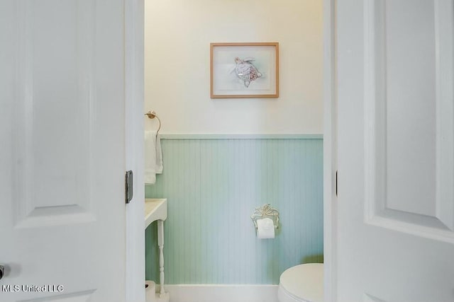 bathroom with wainscoting and toilet