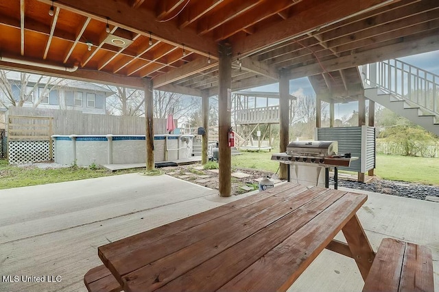 view of patio / terrace featuring stairs, fence, an outdoor pool, and area for grilling