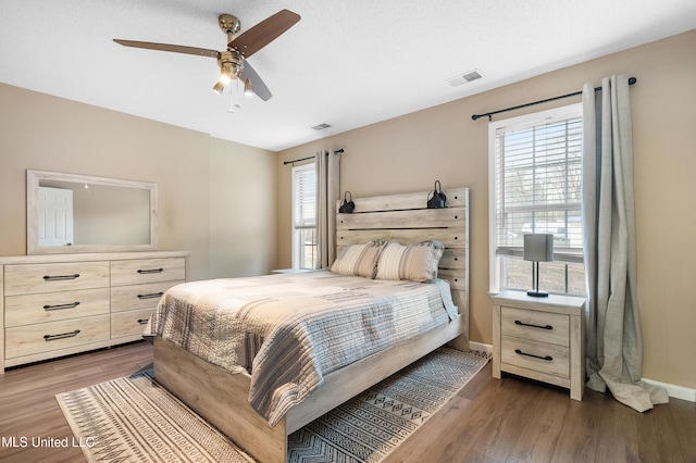 bedroom featuring multiple windows, wood finished floors, and visible vents