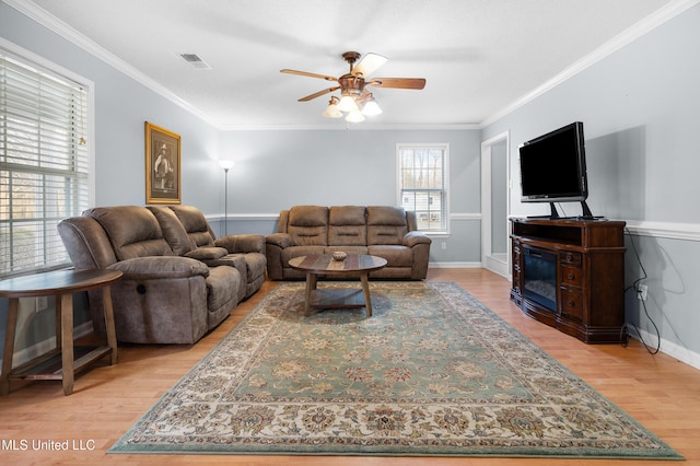 living area featuring visible vents, ceiling fan, light wood-style flooring, and crown molding