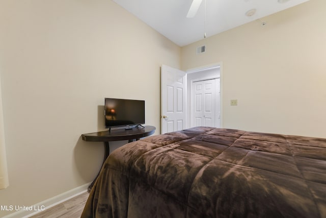 bedroom featuring hardwood / wood-style floors, ceiling fan, a closet, and vaulted ceiling