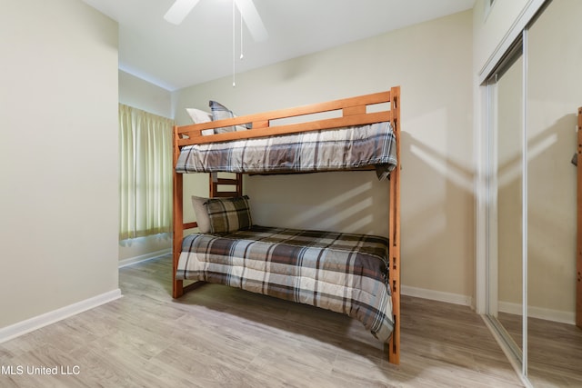 bedroom featuring light hardwood / wood-style floors, ceiling fan, and a closet