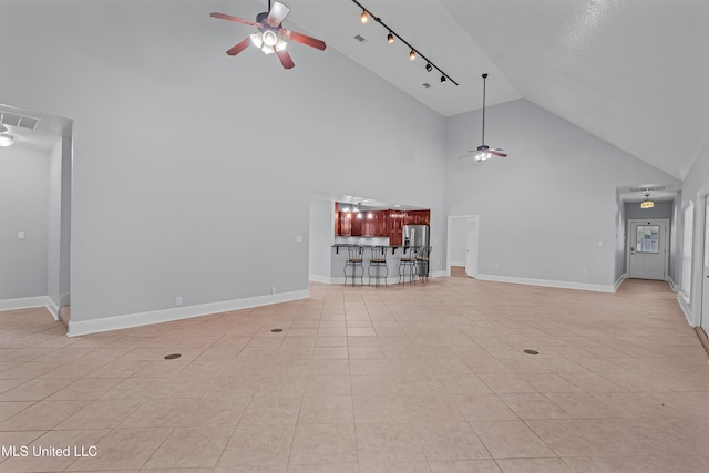 unfurnished living room with light tile patterned floors, high vaulted ceiling, and ceiling fan