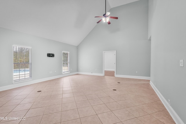 unfurnished living room with ceiling fan, light tile patterned floors, and high vaulted ceiling