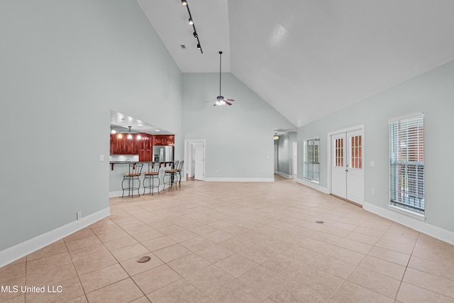 unfurnished living room with rail lighting, high vaulted ceiling, ceiling fan, and light tile patterned flooring