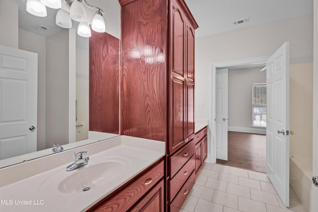 bathroom featuring tile patterned floors, vanity, and a tub to relax in