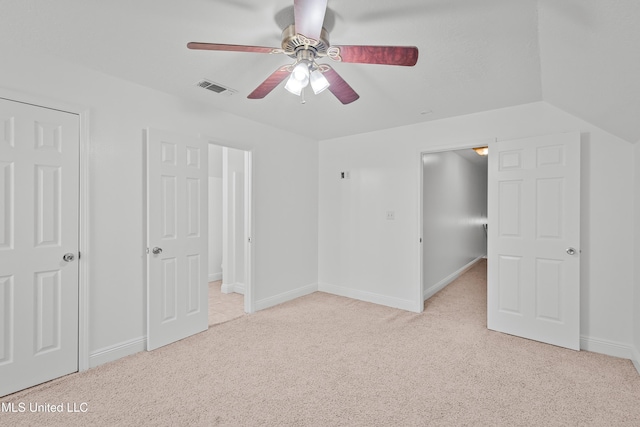 unfurnished bedroom with ceiling fan, light colored carpet, and vaulted ceiling