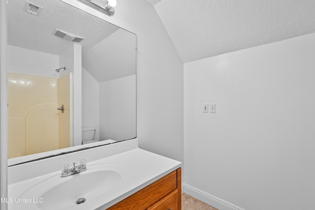 bathroom featuring a shower, a textured ceiling, toilet, and vaulted ceiling