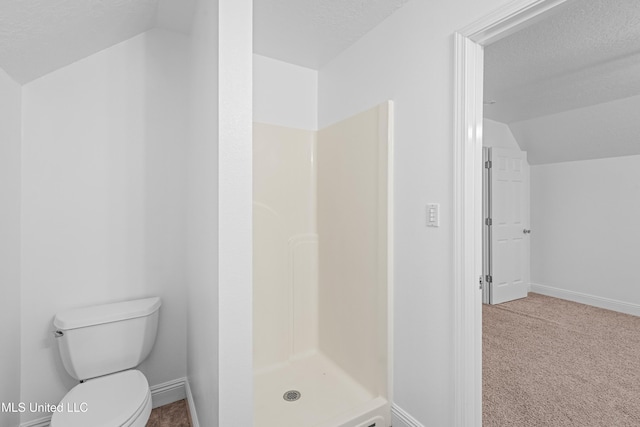 bathroom with a shower, a textured ceiling, toilet, and lofted ceiling