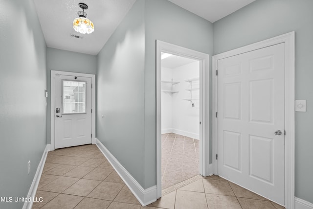 doorway to outside with light tile patterned floors