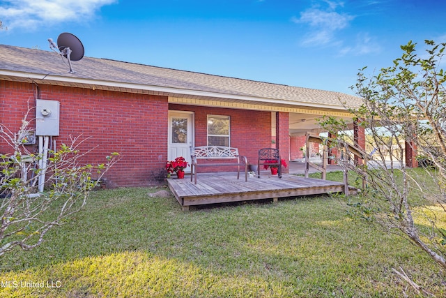 rear view of house featuring a lawn and a deck