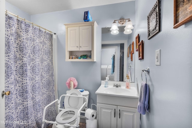 bathroom featuring vanity, toilet, walk in shower, and washer / clothes dryer