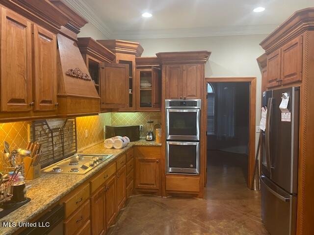 kitchen with stainless steel appliances, crown molding, custom range hood, and tasteful backsplash