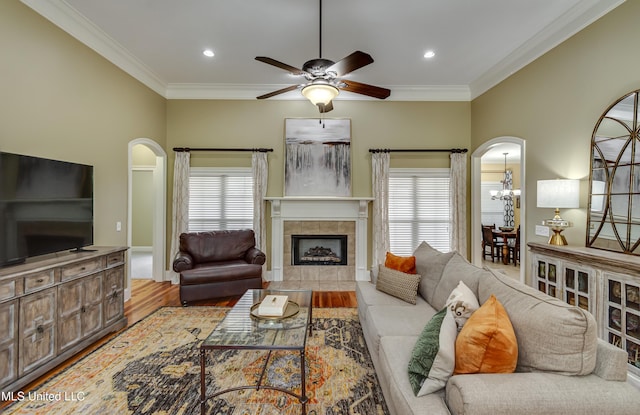718 Tortoise Rdg, Brandon, MS 39047 - living area featuring arched walkways, a ceiling fan, crown molding, wood finished floors, and a tiled fireplace