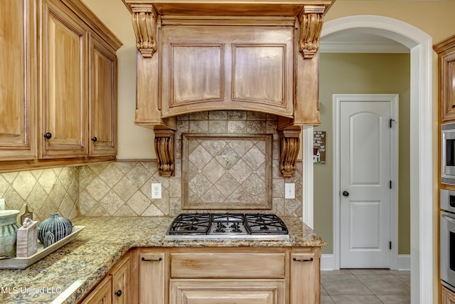 718 Tortoise Rdg, Brandon, MS 39047 - kitchen with stainless steel appliances, arched walkways, light tile patterned floors, light stone countertops, and decorative backsplash