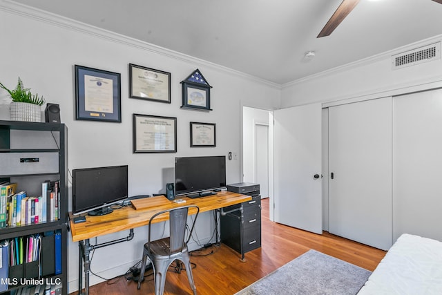 home office with ornamental molding, light wood-type flooring, and ceiling fan