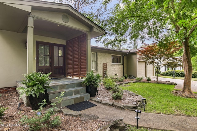 doorway to property with a yard, a garage, and covered porch