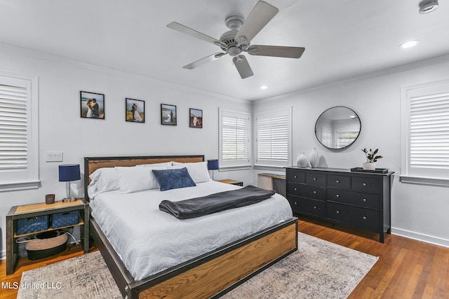 bedroom featuring ceiling fan, ornamental molding, and dark hardwood / wood-style flooring