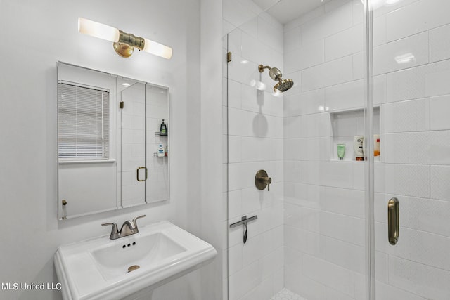 bathroom with sink and a shower with shower door