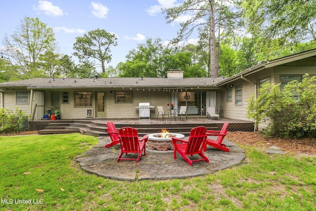 back of house with a yard, a patio, and a fire pit