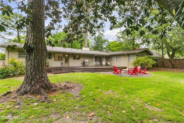 back of house with a patio area, an outdoor fire pit, and a lawn