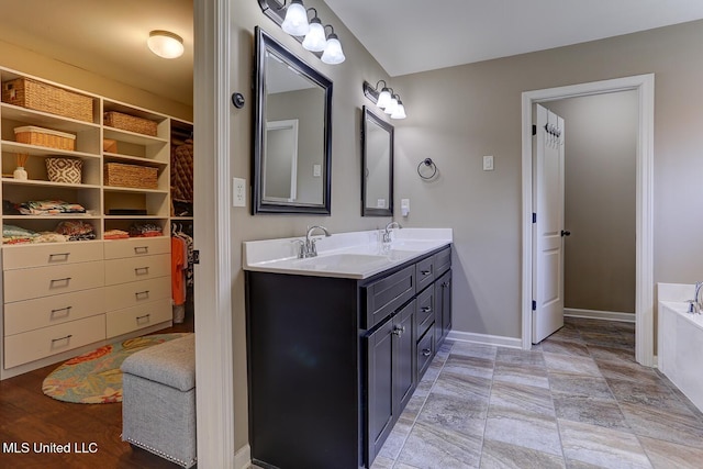 2634 Harvest Tree Dr, Southaven, MS 38672 - bathroom with double vanity, a tub, and stone finish floors