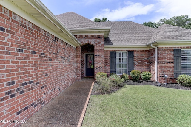 2634 Harvest Tree Dr, Southaven, MS 38672 - view of exterior entry featuring a shingled roof, brick siding, and a lawn