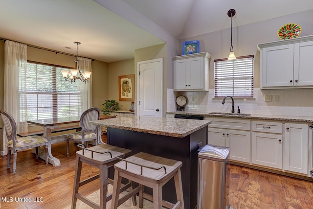 2634 Harvest Tree Dr, Southaven, MS 38672 - kitchen with backsplash, light wood-style floors, a kitchen bar, and lofted ceiling