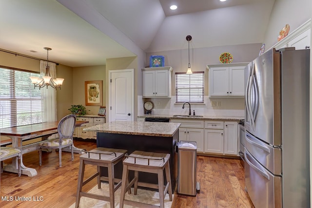 2634 Harvest Tree Dr, Southaven, MS 38672 - kitchen featuring freestanding refrigerator, plenty of natural light, white cabinetry, a kitchen island, and vaulted ceiling