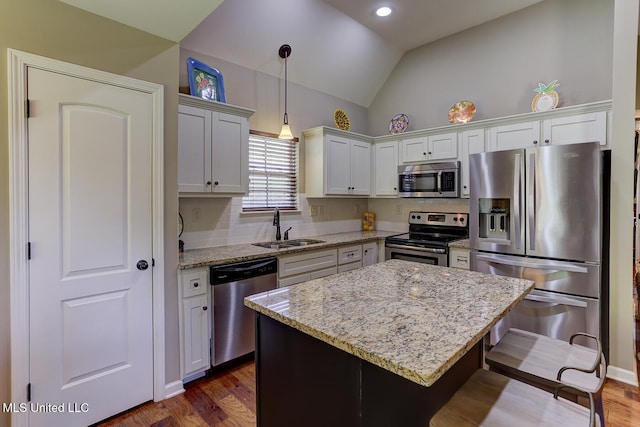 2634 Harvest Tree Dr, Southaven, MS 38672 - kitchen featuring appliances with stainless steel finishes, vaulted ceiling, a kitchen bar, dark wood-style floors, and a center island