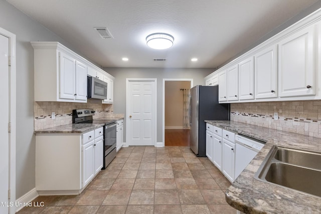 kitchen featuring visible vents, white cabinets, stainless steel appliances, and baseboards