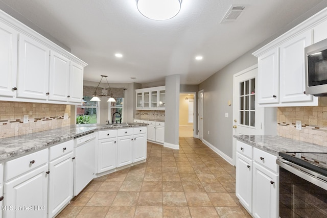 kitchen featuring white cabinetry, visible vents, backsplash, and stainless steel appliances