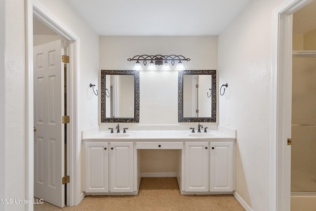 bathroom with a sink, baseboards, a shower with door, and double vanity