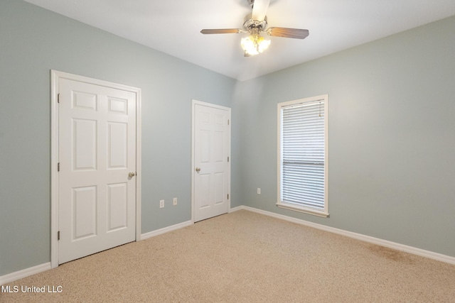 unfurnished bedroom with carpet flooring, a ceiling fan, and baseboards