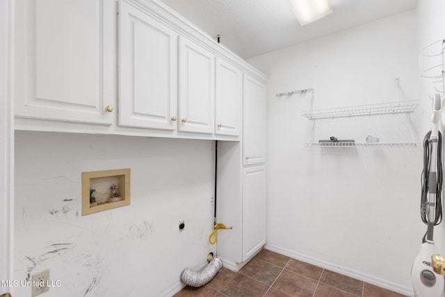 laundry area featuring washer hookup, dark tile patterned flooring, cabinet space, and electric dryer hookup