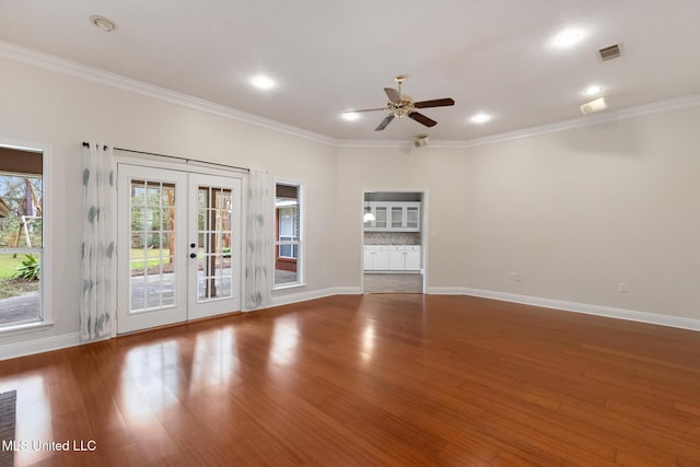 empty room featuring visible vents, ornamental molding, french doors, wood finished floors, and a ceiling fan