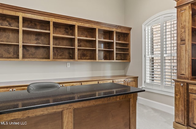 interior space featuring dark stone counters and light carpet