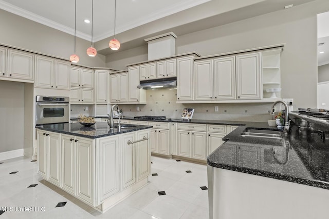 kitchen with stainless steel appliances, sink, hanging light fixtures, and dark stone countertops