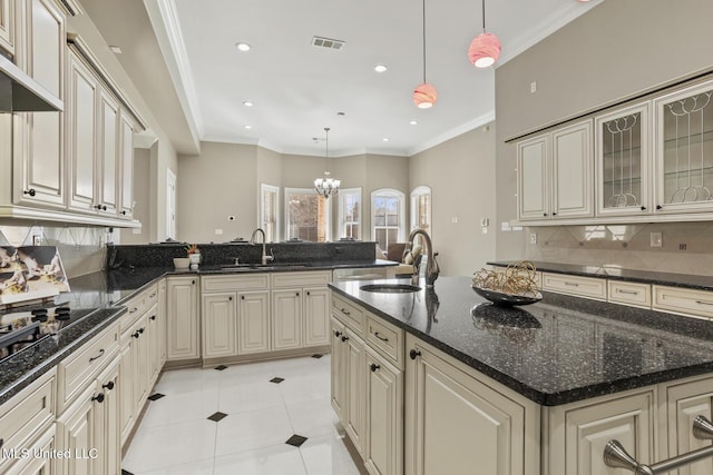 kitchen featuring hanging light fixtures, sink, backsplash, and cream cabinetry