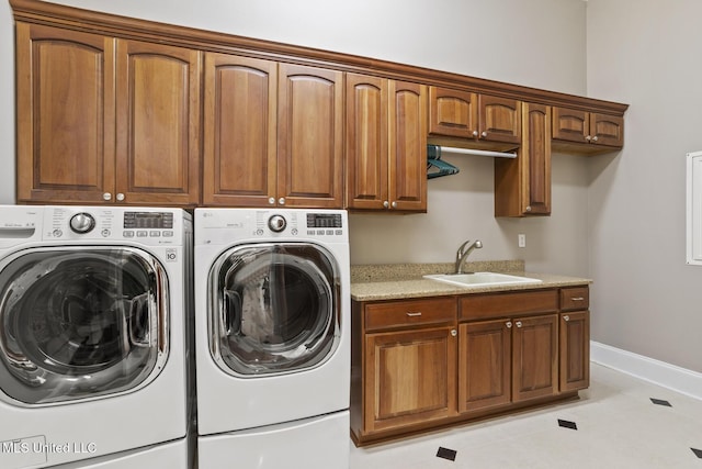 washroom with sink, cabinets, washing machine and clothes dryer, and light tile patterned flooring