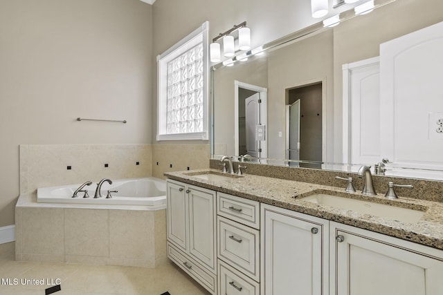 bathroom featuring vanity, tiled tub, and tile patterned flooring