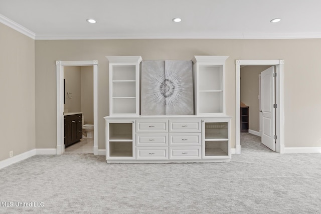 unfurnished bedroom featuring crown molding, ensuite bath, and light carpet